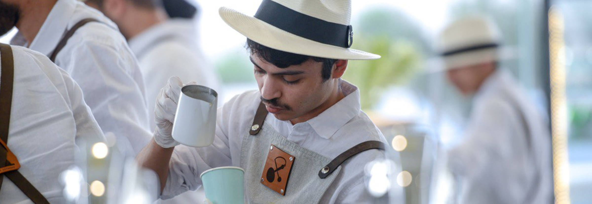 A Middle Eastern specialty coffee barista pours latte art.