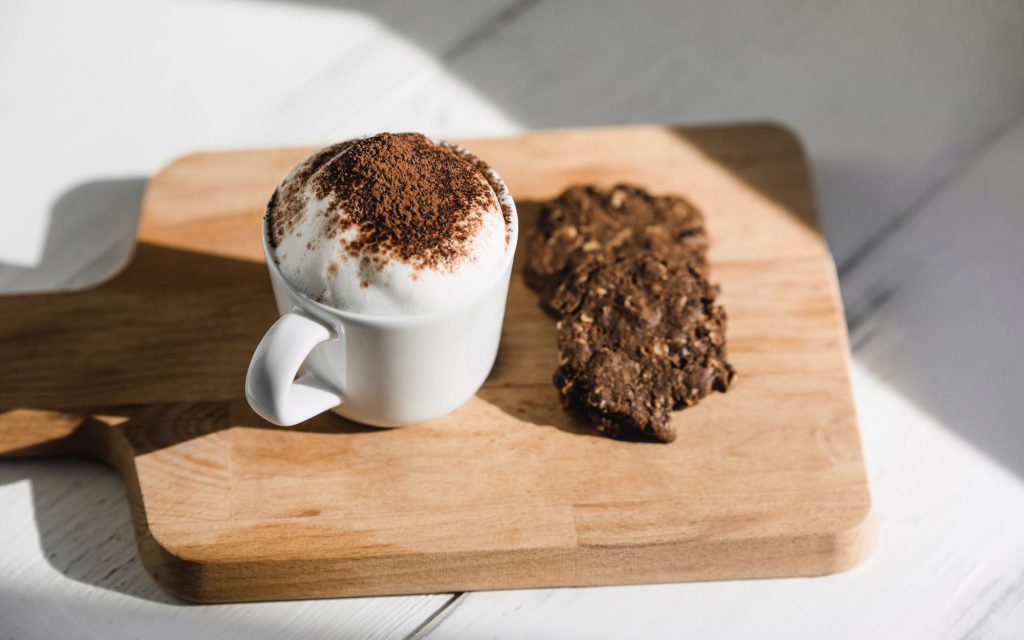 a babyccino next to a cookie
