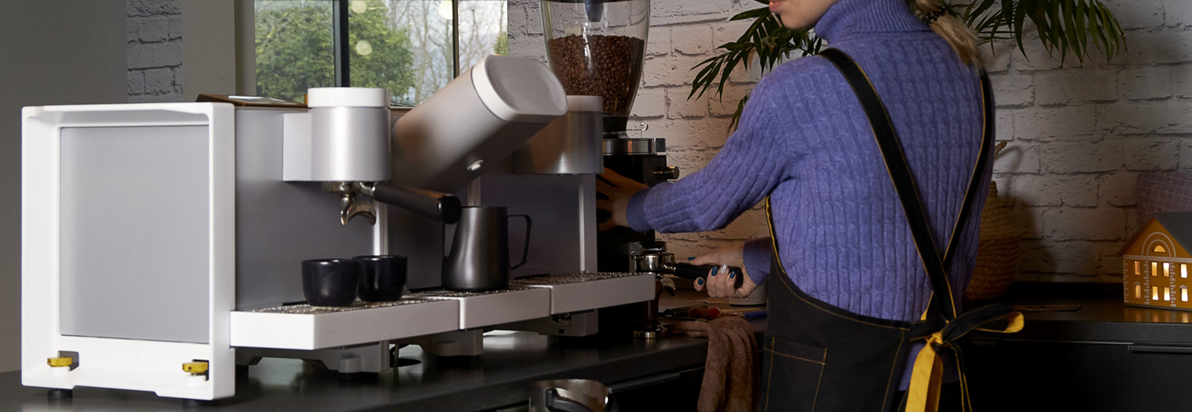 A barista uses a Heylo coffee machine in a sustainable coffee shop.