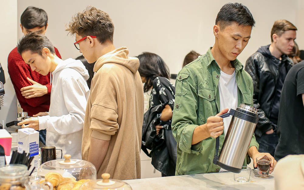 People brew and serve coffee at an event held at Spectre Coffee in Kazakhstan.
