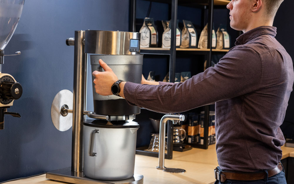 A barista prepares coffee concentrate using the Marco ColdBRU system.