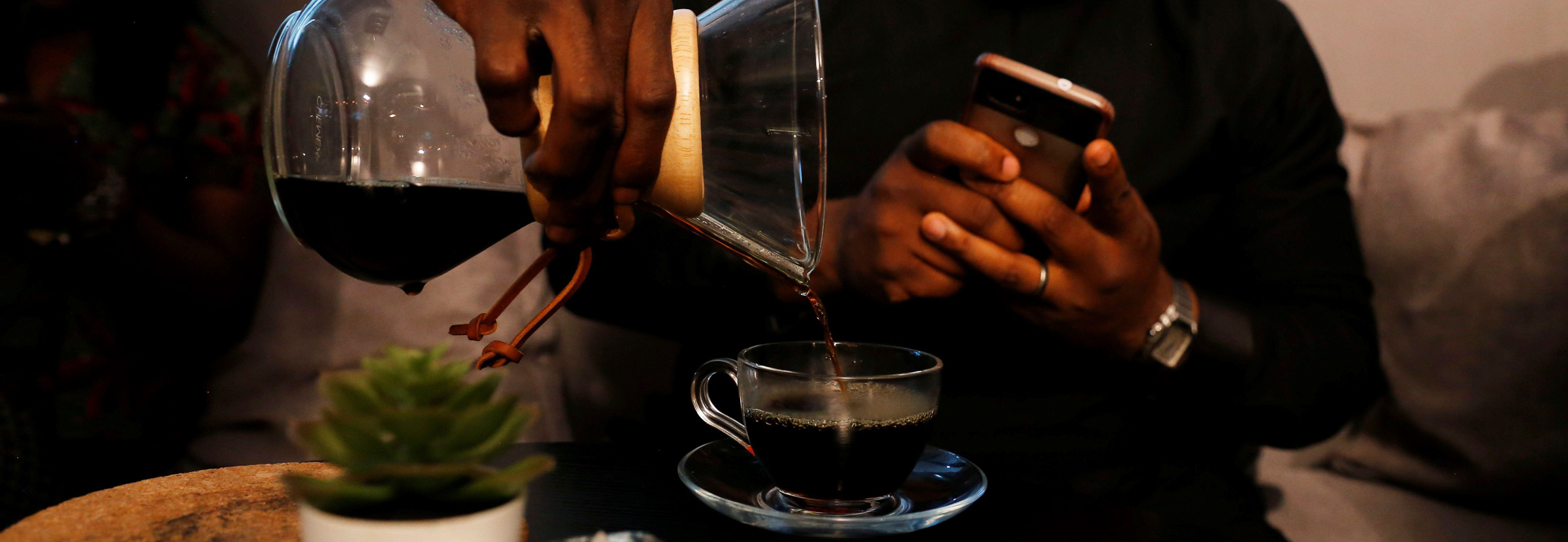 A barista pours coffee from a chemex in Nigeria